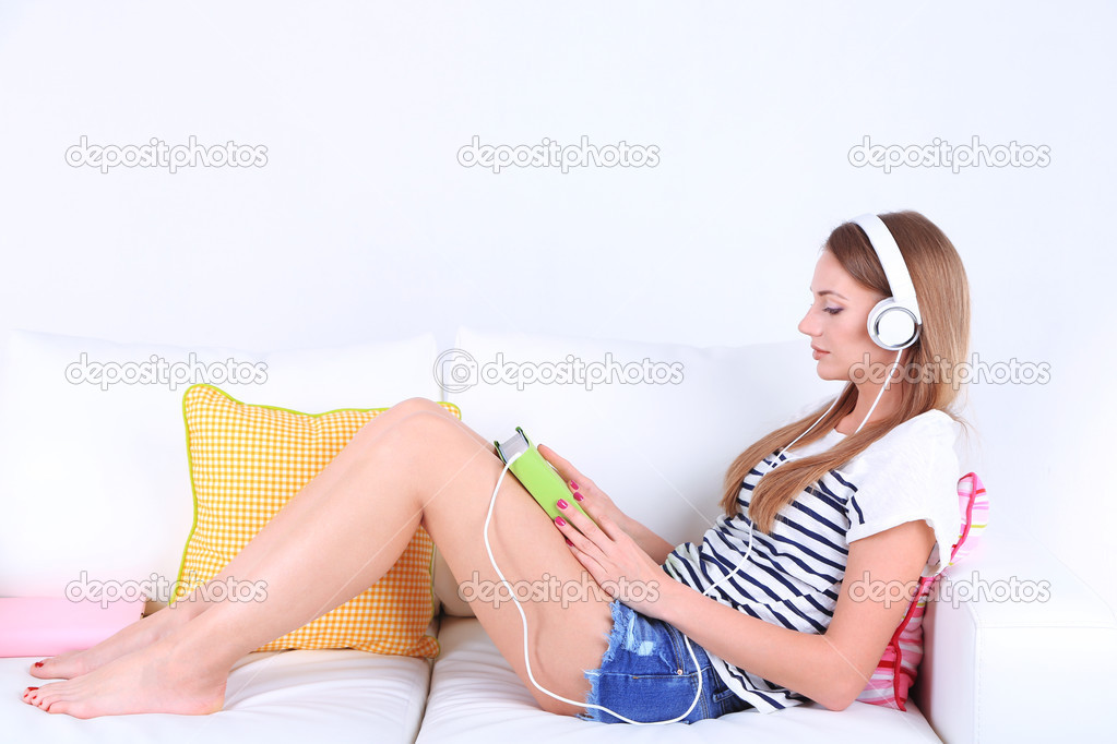 Conceptual image of  audio book.Beautiful girl with book and headphones.