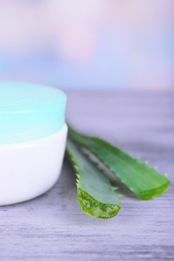 ahşap masa krem ve taze yeşil aloe yapraklarda