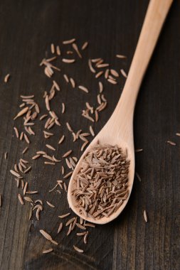 ahşap zemin üzerine kaşık içinde baharat kimyon