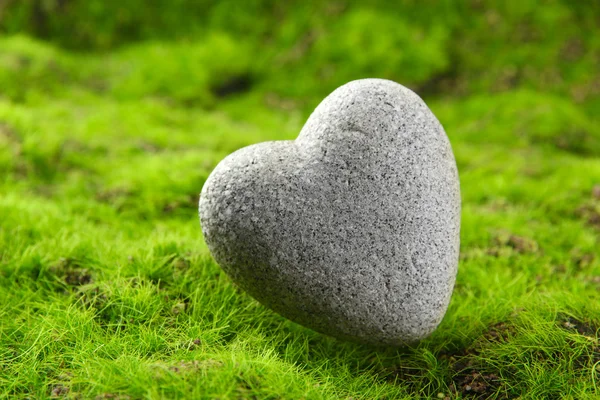 Piedra gris en forma de corazón, sobre fondo de hierba —  Fotos de Stock