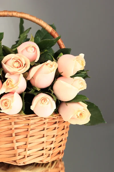 Красивий букет троянд в кошику на сірий фон — Zdjęcie stockowe