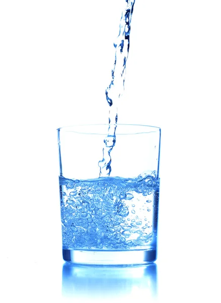 Pouring water into glass on blue background — Stock Photo, Image