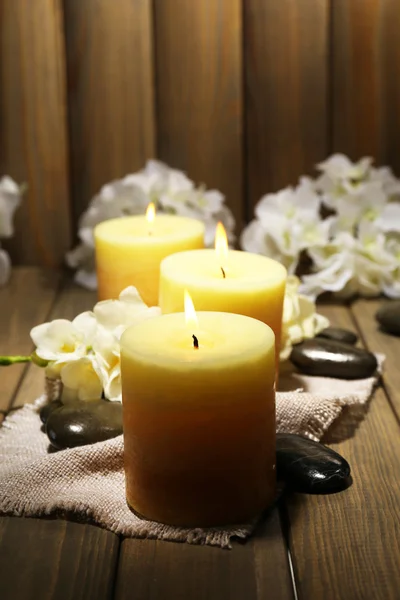 Belas velas com flores no fundo de madeira — Fotografia de Stock