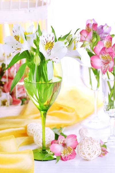 Freesias em óculos na mesa no fundo do tecido — Fotografia de Stock