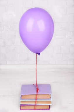 Gri duvar arkaplanı üzerine kitapları olan renkli balon
