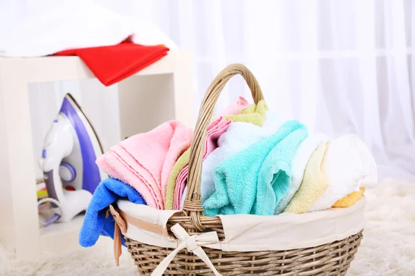 Kleurrijke handdoeken in mand op huis interieur achtergrond — Stockfoto