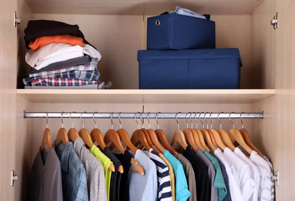 Colorful clothes hanging in wardrobe — Stock Photo, Image