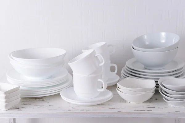 Set de platos blancos sobre mesa sobre fondo claro — Foto de Stock