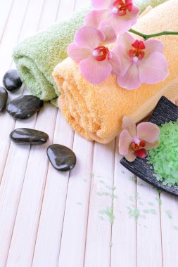 güzel çiçek ile natürmort orkide çiçek, havlu ve deniz tuzu, renk ahşap arka plan üzerine bir kase