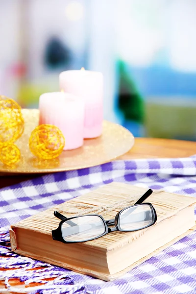 Composition with old book, eye glasses, candles and plaid on bright background — Stock Photo, Image