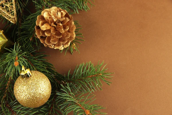 Beautiful Christmas decorations on fir tree on brown background — Stock Photo, Image