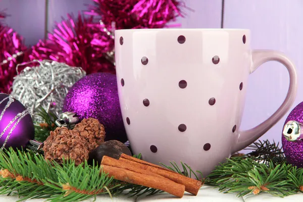 Cup of hot cacao with chocolates and Christmas decorations on table on wooden background