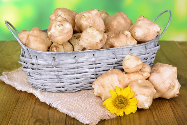 Topinambur roots in wicker basket on table on bright background — Stock Photo, Image