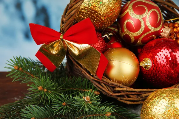 Decoraciones navideñas en cesta y ramas de abeto sobre fondo brillante —  Fotos de Stock