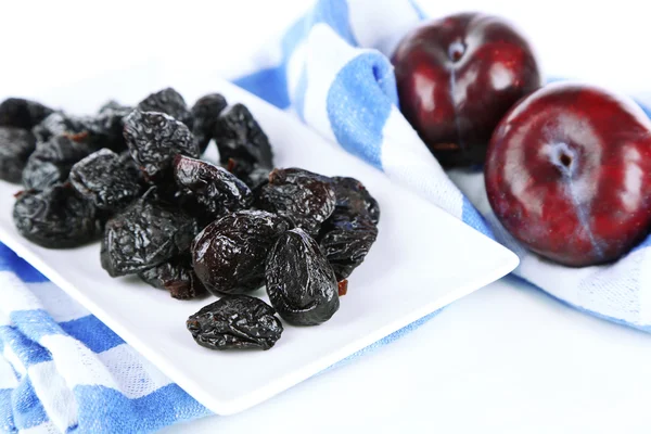 Fresh and dried plums  on napkin, isolated on white — Stock Photo, Image