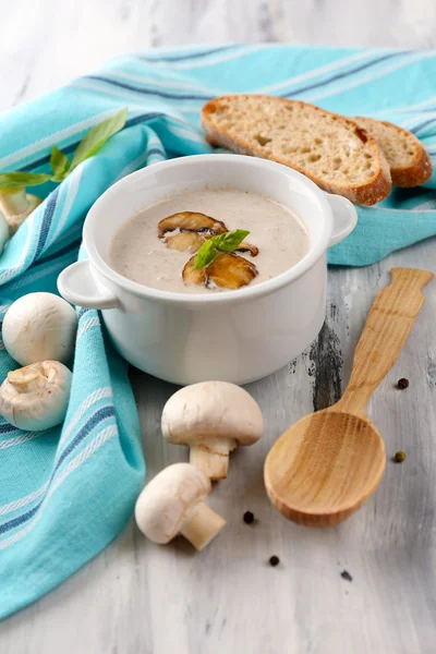 Mushroom soup in white pot, on napkin,  on wooden background — Stock Photo, Image