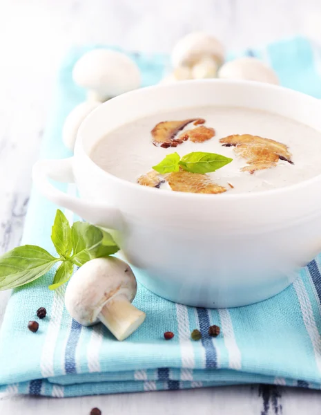 Mushroom soup in white pot, on napkin,  on wooden background — Stock Photo, Image