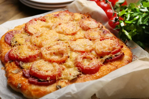 Homemade pizza on baking paper close up — Stock Photo, Image