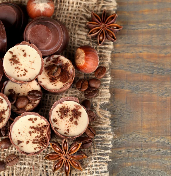 Νόστιμα σοκολάτας καραμέλες με κόκκους καφέ και καρύδια σε ξύλινα φόντο — Φωτογραφία Αρχείου