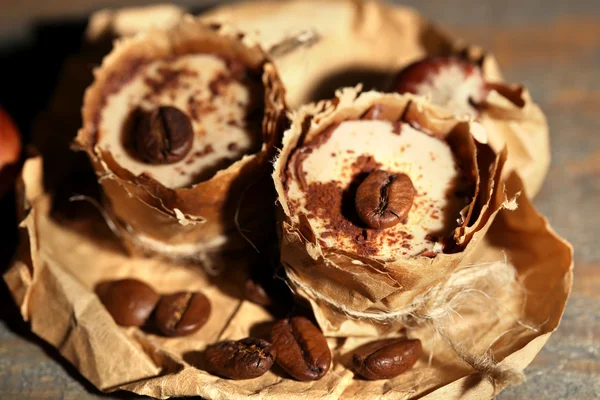 Kahve çekirdekleri ve ahşap zemin üzerine fındık ile lezzetli çikolata şekerleme — Stok fotoğraf