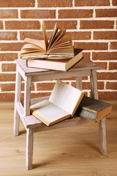 Libri su scala in legno su sfondo parete a colori — Foto Stock