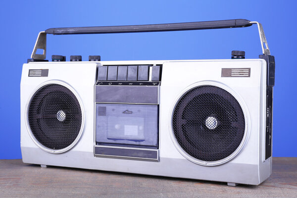 Retro cassette stereo recorder on table on blue background