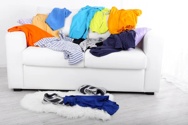 Messy colorful male clothing on  sofa on light background — Stock Photo, Image