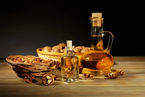 Walnut oil and nuts on wooden table — Stock Photo, Image
