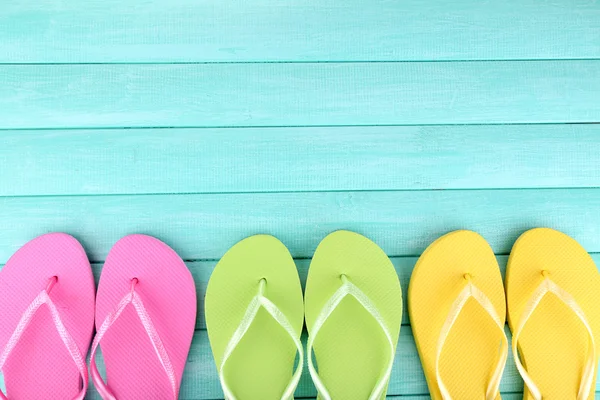 Bright flip-flops on color wooden background — Stock Photo, Image