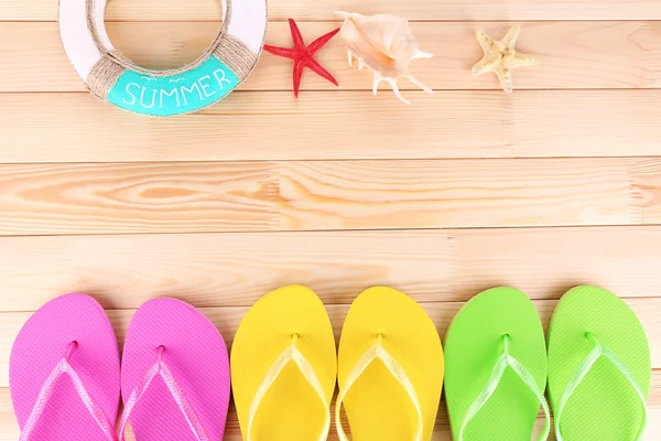 Bright flip-flops on wooden background — Stock Photo, Image