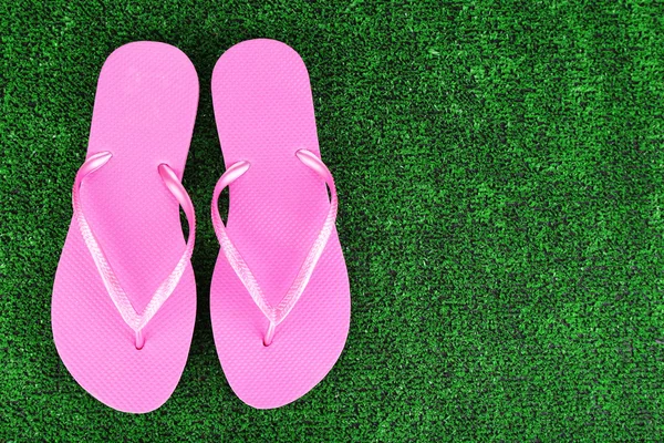 Bright flip-flops on green grass background — Stock Photo, Image