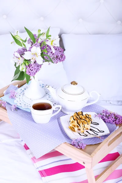 Light breakfast and beautiful bouquet on bed — Stock Photo, Image