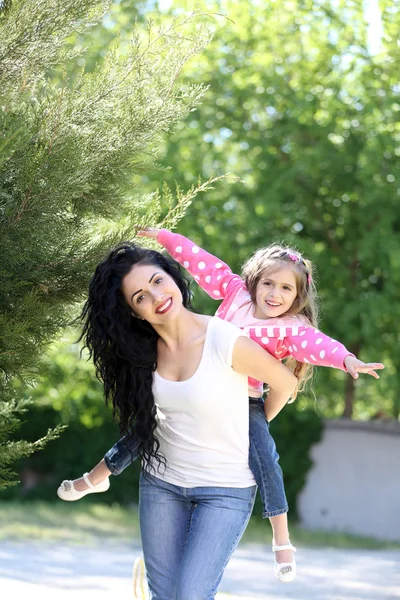 Feliz mamá y su hija. Caminar por el parque verde —  Fotos de Stock