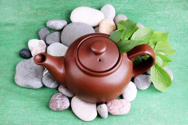 Tetera con flores secas e ingredientes de hierbas para el té, sobre piedras y color fondo de madera — Foto de Stock