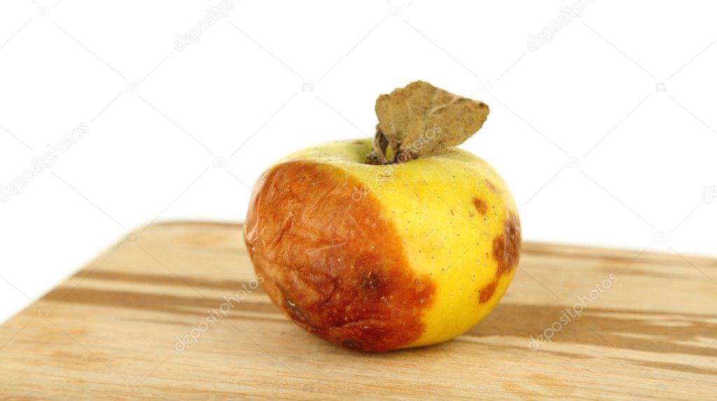 Rotten apple on wooden board isolated on white