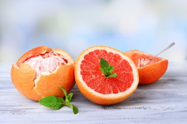 parlak arka plan üzerinde renkli ahşap masa üzerinde olgunlaşmış soyulmuş greyfurt