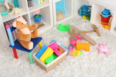 Çocuk odasında tüylü halı üzerinde renkli oyuncaklar