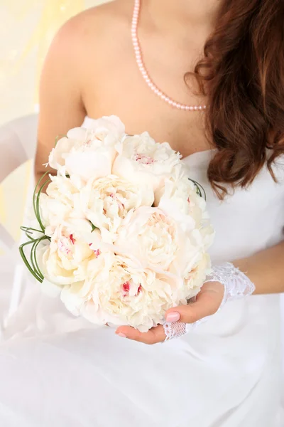 Bride holding wedding bouquet of white peonies, close-up, on light background — Stock Photo, Image