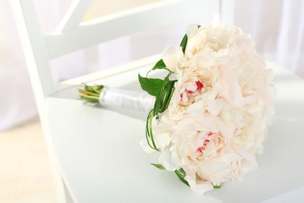 Beautiful wedding bouquet on chair on light background — Stock Photo, Image