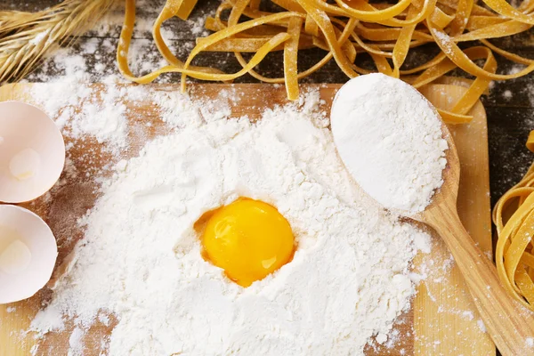 Nature morte avec des pâtes maison crues et des ingrédients pour les pâtes — Photo