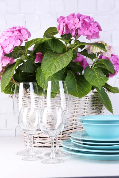 Hortensias et ustensiles fleuris sur table sur fond de mur gris — Photo