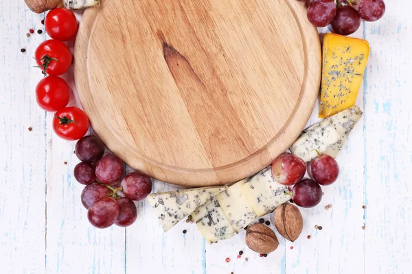 Diferentes tipos de queso con tabla vacía en primer plano — Foto de Stock