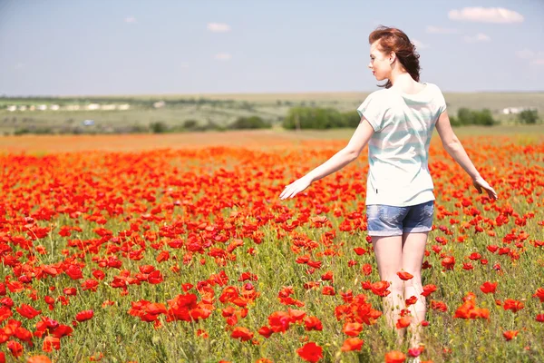 Bella giovane donna nel campo di papavero — Foto Stock