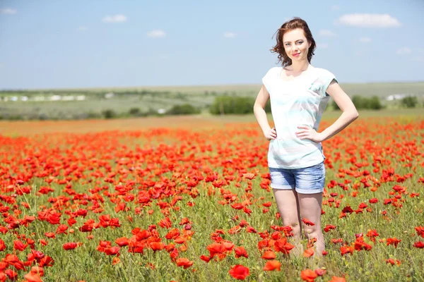 Mooie jonge vrouw in papaverveld — Stockfoto