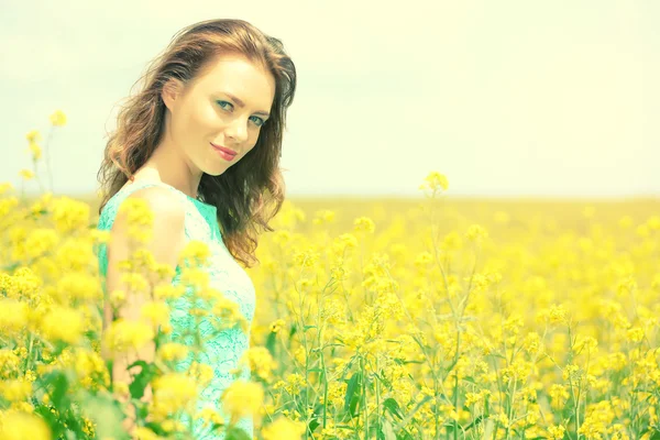 Belle jeune femme dans le champ de fleurs — Photo