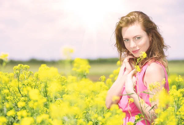 Beautiful young woman in flower field — Stock Photo, Image