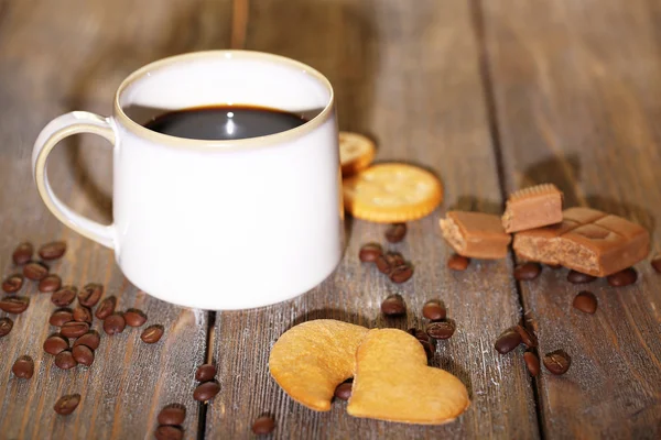 Copo com café quente e biscoitos doces, em fundo de mesa de madeira — Fotografia de Stock