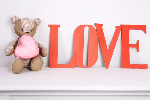 Dekorative Buchstaben bilden Wortliebe mit Teddybär auf Wandhintergrund — Stockfoto