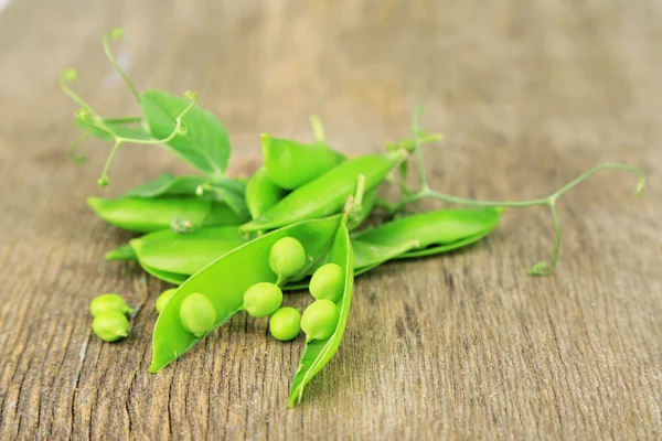 Guisantes verdes frescos en mesa de madera — Foto de Stock