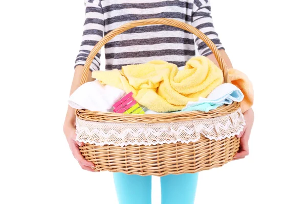 Mulher segurando cesta de lavanderia com roupas limpas, toalhas e pinos, isolado em branco — Fotografia de Stock